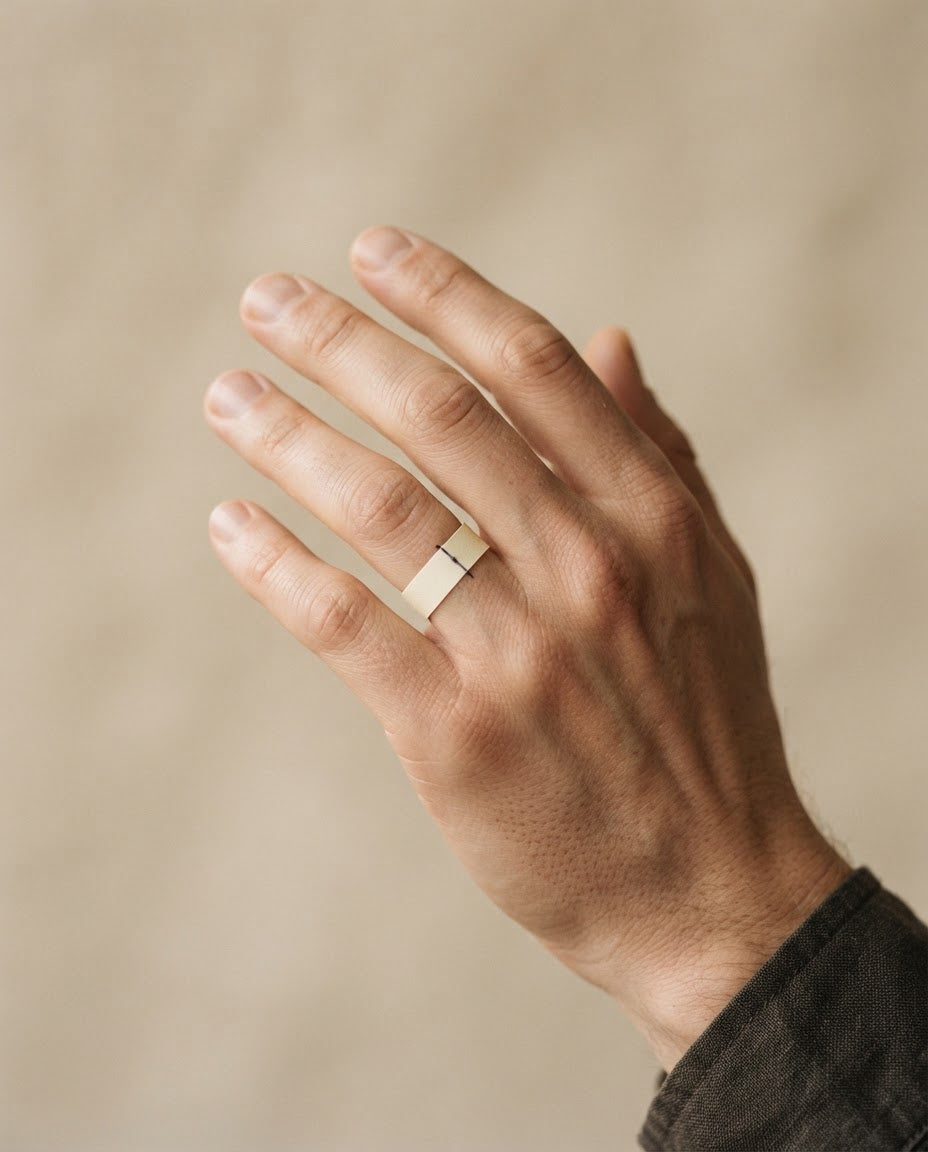 Wrap a thin strip of paper around the base of your finger and mark where it overlaps